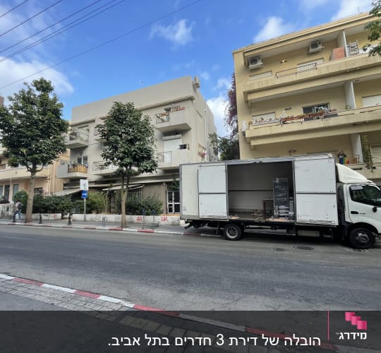 משאית פתוחה עם ציוד מעבר ברחוב עירוני